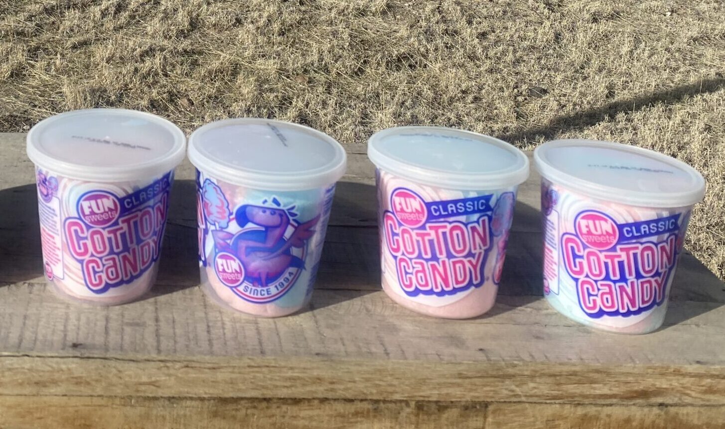 cheerful mini-buckets of cotton candy sit on a wooden bench”/></p>
<div class=