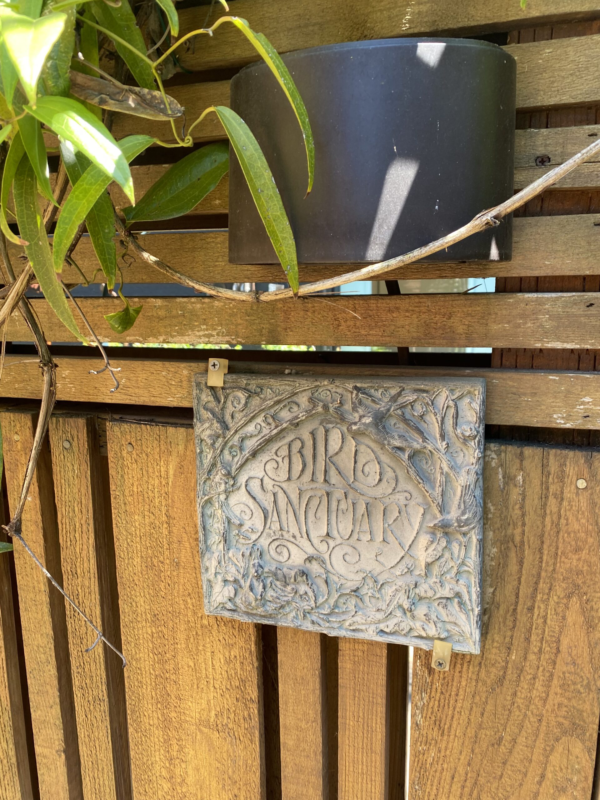 a sign on a wooden fence tells you about a (bird) sanctuary